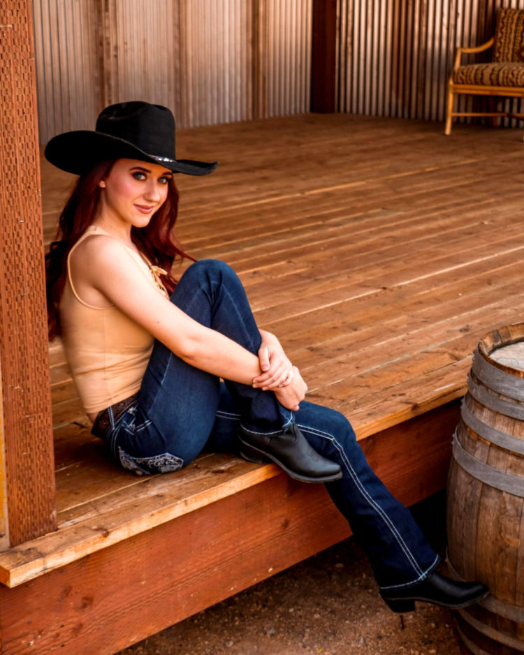 Photo of Ashley Wineland, seated on wood deck.